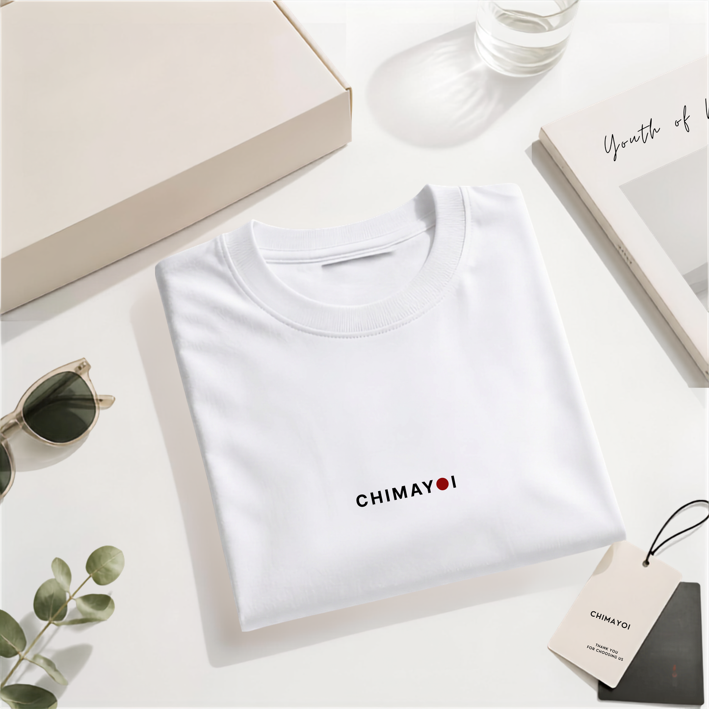 Flat lay of CHIMAYOI White embroidered logo tee folded neatly with minimalist props, showcasing high-end streetwear details.