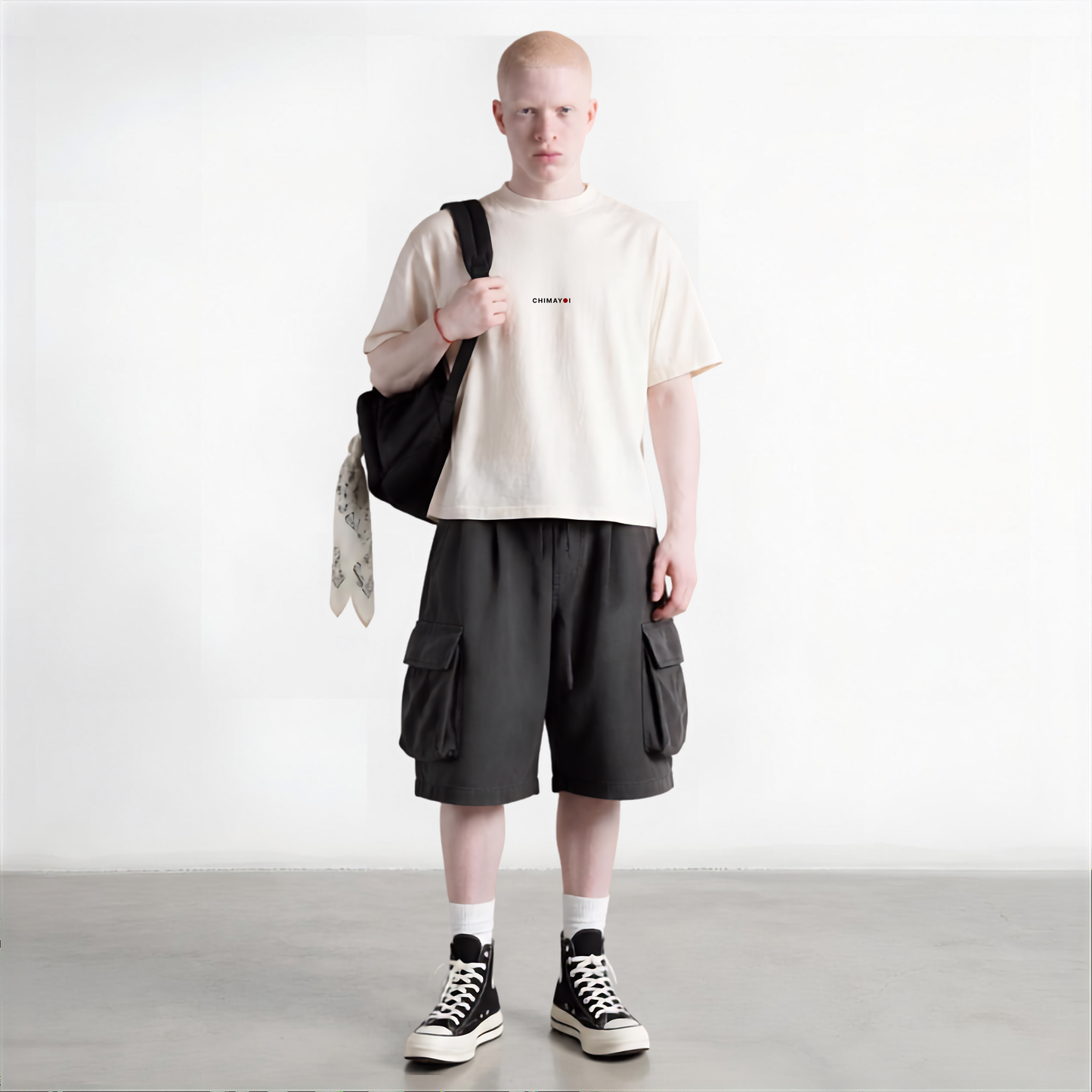 Male model wearing CHIMAYOI off-white minimalist streetwear tee with black cargo shorts and tote bag.