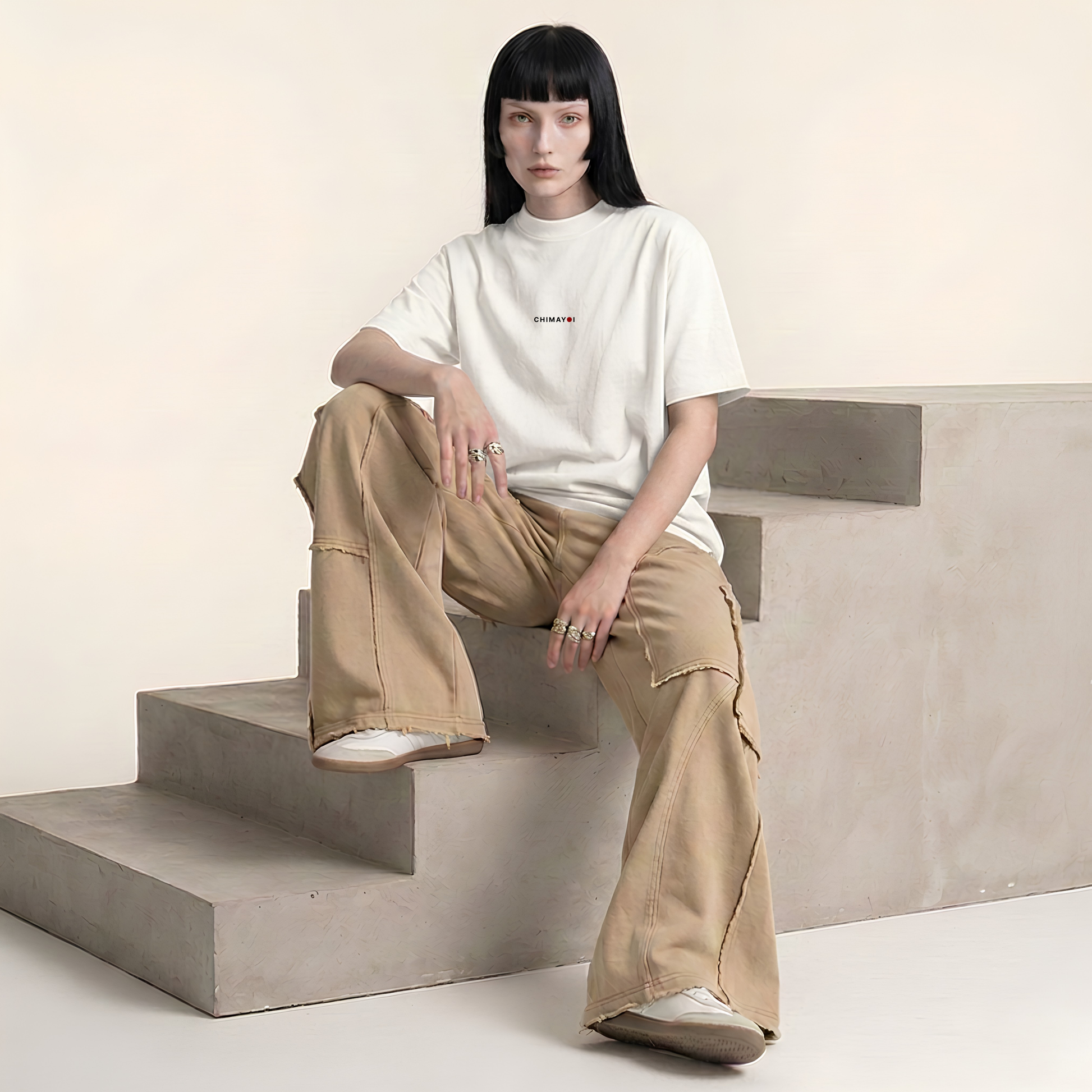Female model styling the CHIMAYOI off-white cropped tee with wide-leg pants, illustrating unisex quiet luxury streetwear.