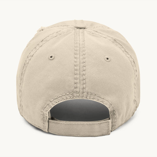 The back view of a beige baseball cap with a stitched crown and adjustable snapback closure and clean rear stitching.
